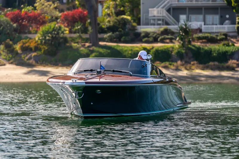 Slide: The Image of 2026 Riva 33' Aquariva Special cruising on a serene lake near lush greenery. - 10