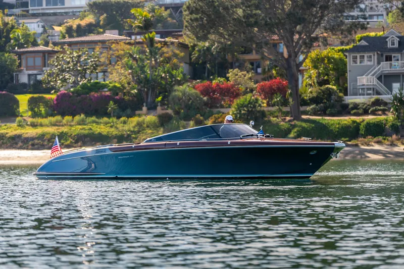 Slide: The Image of 2026 Riva 33' Aquariva Special luxury boat cruising near scenic shoreline. - 12