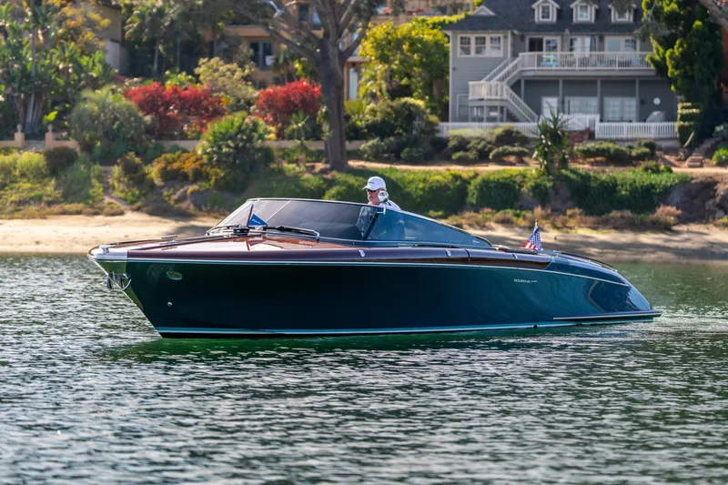 Slide: The Image of 2026 Riva 33' Aquariva Special cruising on a serene lake with lush greenery. - 9