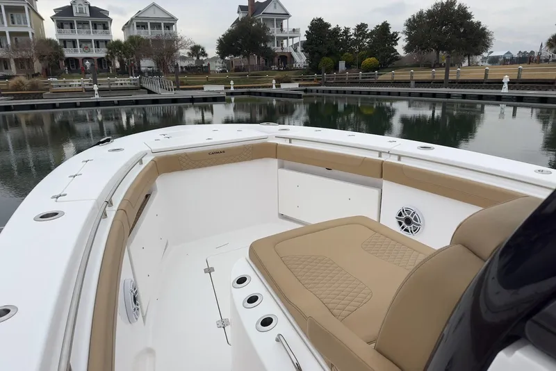 Slide: The Image of 2023 Caymas 341 CC boat interior with tan seating, docked near waterfront homes. - 11