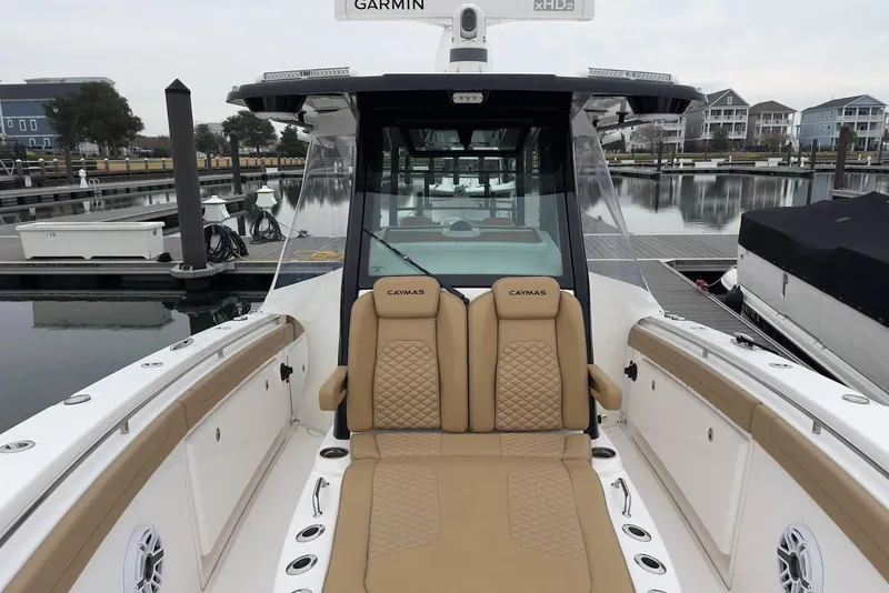 Slide: The Image of 2023 Caymas 341 CC boat with tan seating, docked at a marina. - 8