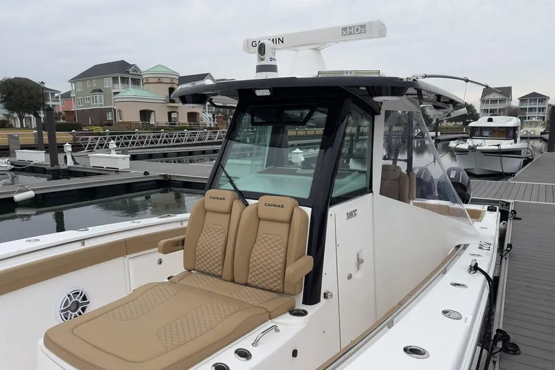 Slide: The Image of 2023 Caymas 341 CC boat docked, featuring tan seating and modern design. - 9