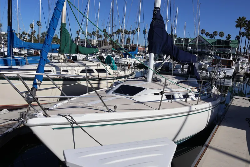 Slide: The Image of 1988 Catalina 30 MkII sailboat docked in a marina, surrounded by other boats. - 1