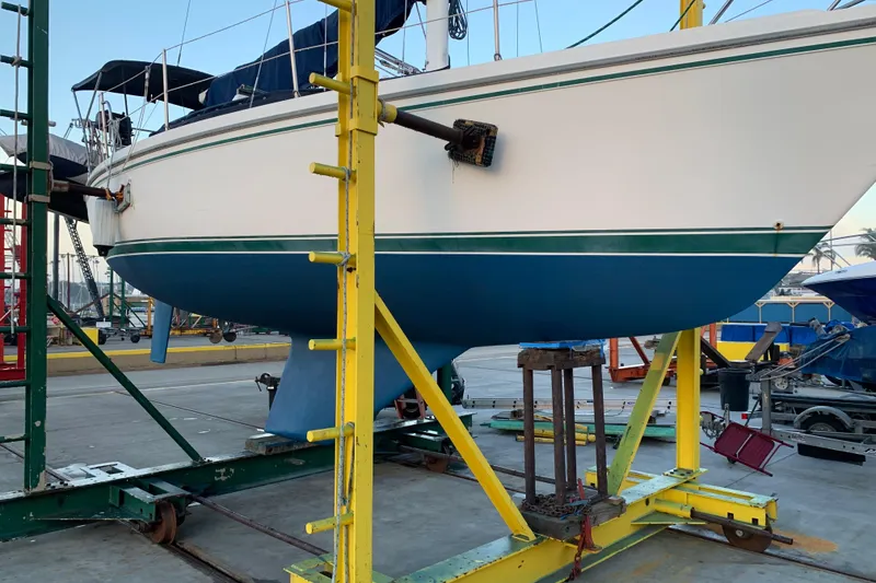 Slide: The Image of 1988 Catalina 30 MK11 sailboat on dry dock, supported by yellow stands. - 11