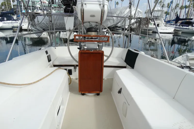 Slide: The Image of Cockpit of 1988 Catalina MKII sailboat with steering wheel and seating, docked in marina. - 12