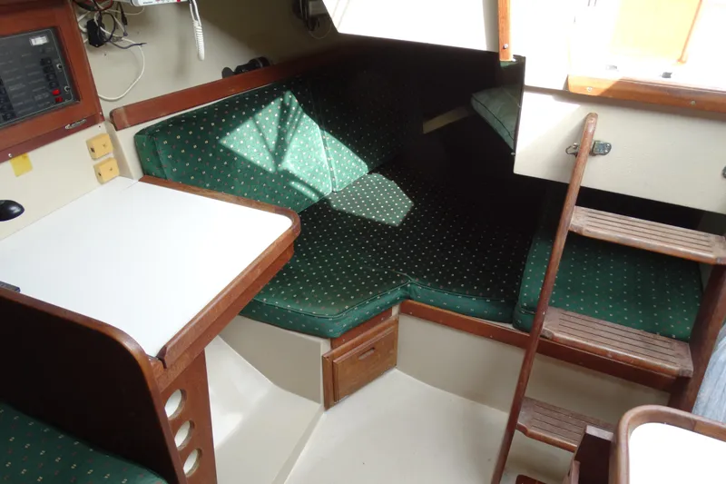 Slide: The Image of Interior of 1988 Catalina MKII sailboat with green cushioned seating and wooden ladder. - 14