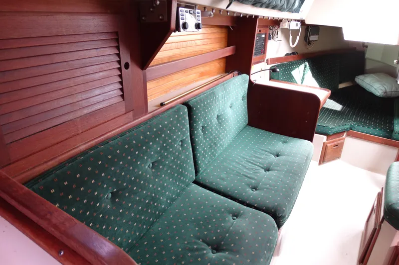 Slide: The Image of Interior of 1988 Catalina MKll sailboat with green cushioned seating and wooden accents. - 18