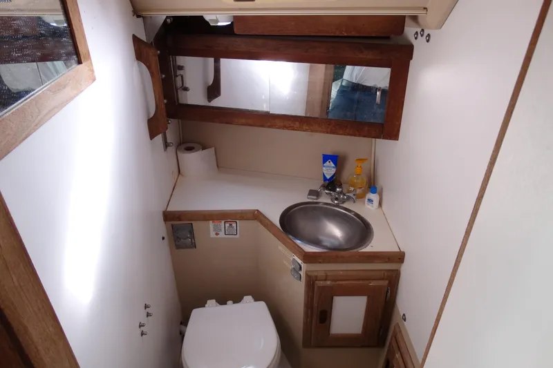 Slide: The Image of Compact bathroom in a 1988 Catalina MKll boat with sink, mirror, and toilet. - 20