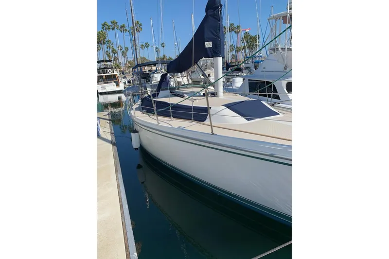Slide: The Image of 1988 Catalina 30 MkII sailboat docked in a marina, surrounded by other boats. - 3