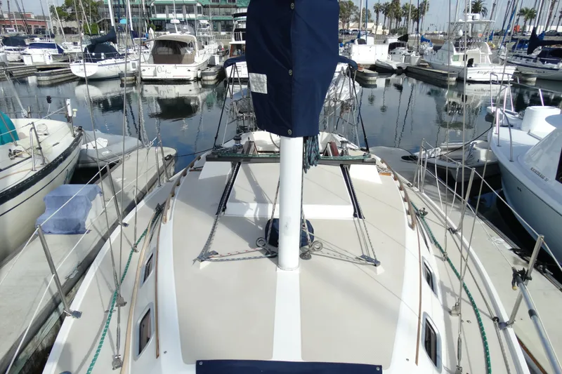 Slide: The Image of 1988 Catalina MKll sailboat docked in a marina, surrounded by other boats. - 34