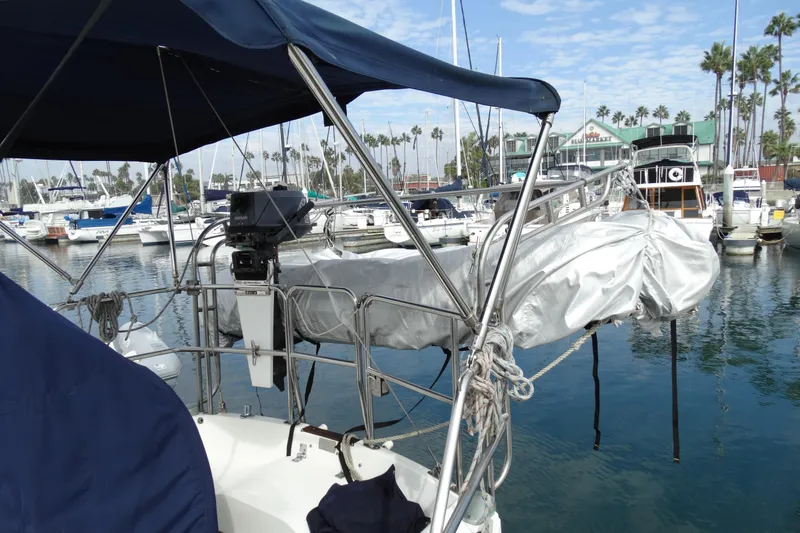 Slide: The Image of 1988 Catalina MKII sailboat docked in marina with covered equipment and clear sky. - 8