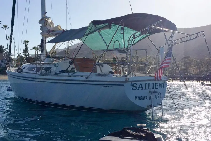 Slide: The Image of 1988 Catalina MKII sailboat anchored in sunny marina with American flag. - 9