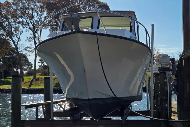 Slide: The Image of 2015 May-Craft 2550 Pilot XL boat docked, front view, sunny day. - 10