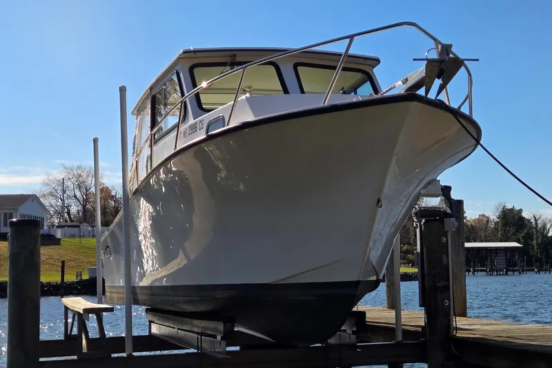 Slide: The Image of 2015 May-Craft 2550 Pilot XL boat docked on a sunny day. - 11