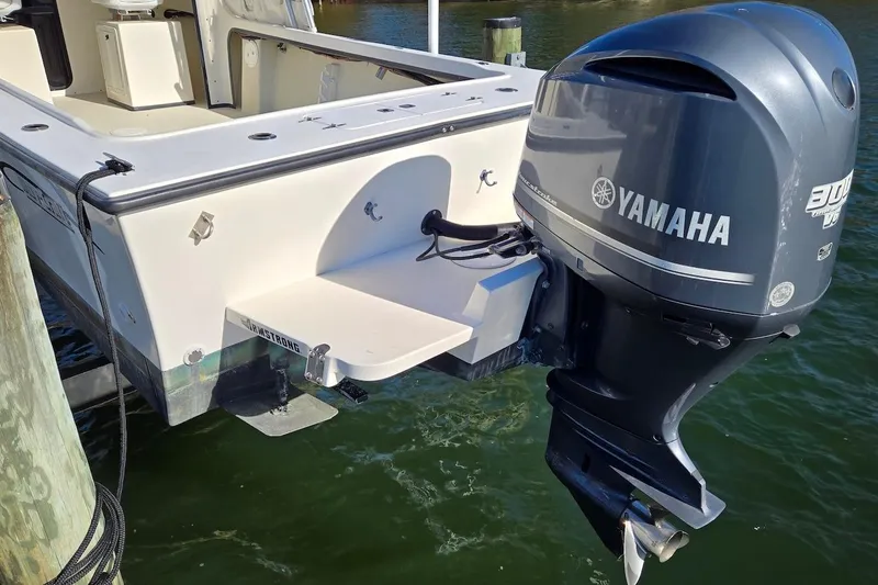 Slide: The Image of 2015 May-Craft 2550 Pilot XL with Yamaha 300 outboard motor, docked on calm water. - 14