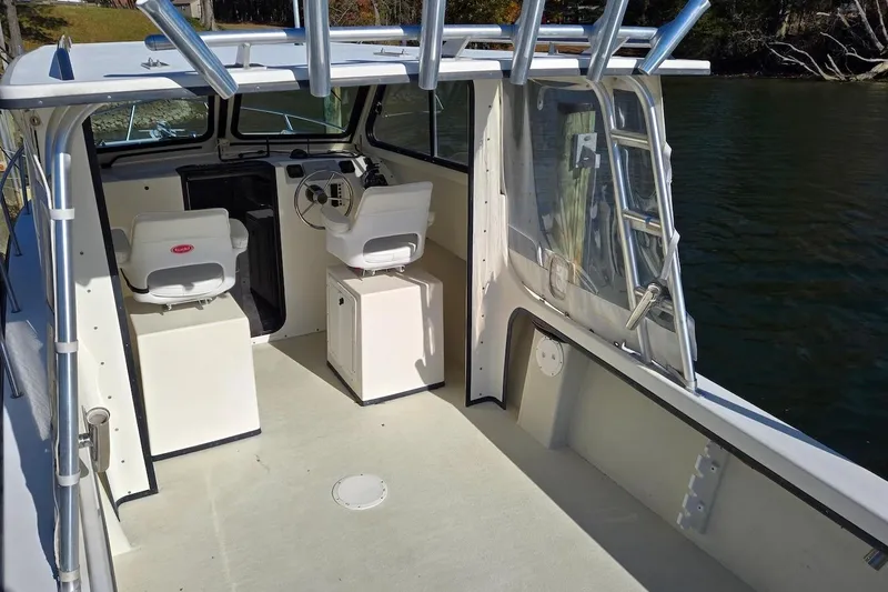 Slide: The Image of 2015 May-Craft 2550 Pilot XL boat interior with helm and seating. - 15