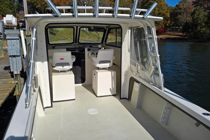 Slide: The Image of 2015 May-Craft 2550 Pilot XL boat interior with dual seats and steering wheel. - 16