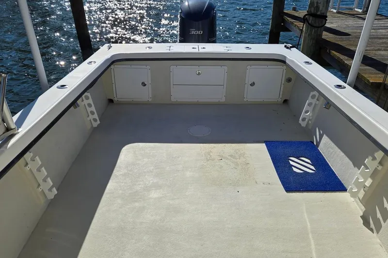Slide: The Image of 2015 May-Craft 2550 Pilot XL boat deck with storage compartments and blue mat. - 18