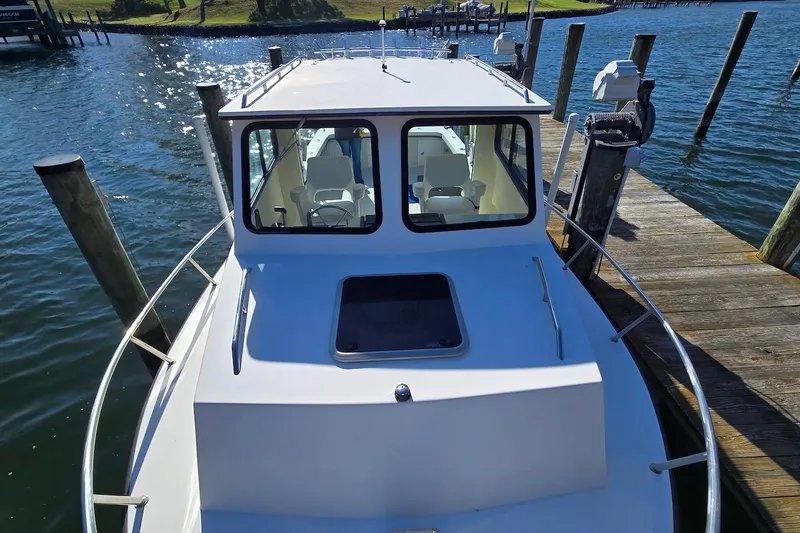 Slide: The Image of 2015 May-Craft 2550 Pilot XL boat docked on a sunny day. - 19