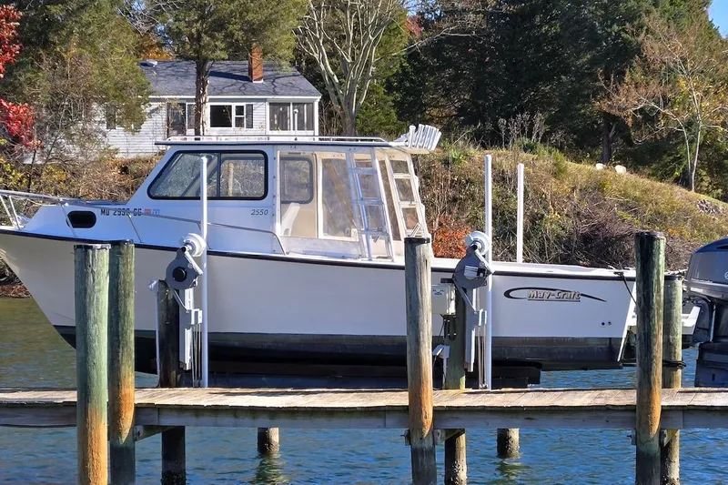 Slide: The Image of 2015 May-Craft 2550 Pilot XL boat docked by a scenic waterfront. - 2
