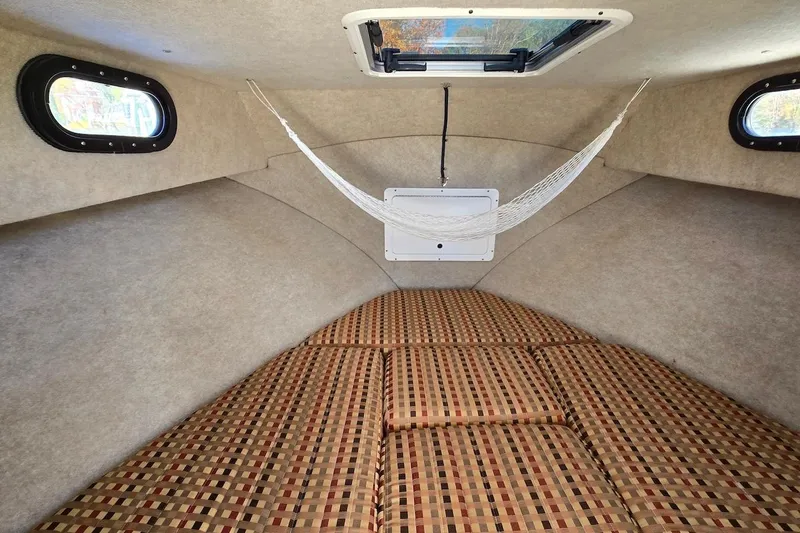 Slide: The Image of Interior cabin of 2015 May-Craft 2550 Pilot XL with hammock and patterned cushions. - 23