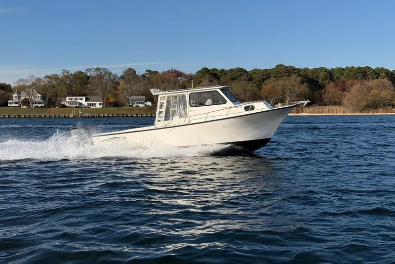 Slide: The Image of 2015 May-Craft 2550 Pilot XL boat cruising on a scenic waterway. - 4