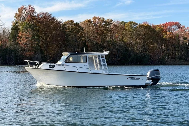 Slide: The Image of 2015 May-Craft 2550 Pilot XL boat cruising on a scenic lake with autumn trees. - 5