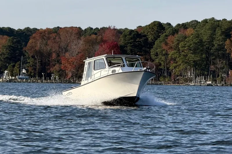 Slide: The Image of 2015 May-Craft 2550 Pilot XL boat cruising on a scenic lake with autumn trees. - 7