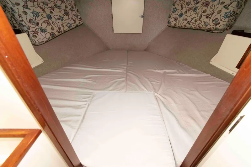 Slide: The Image of 1999 Camano 31 Troll boat interior cabin with bed and nautical-themed cushions. - 10