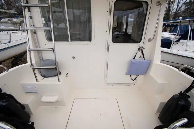 Slide: The Image of 1999 Camano 31 Troll boat deck with ladder and door, showcasing spacious layout. - 2