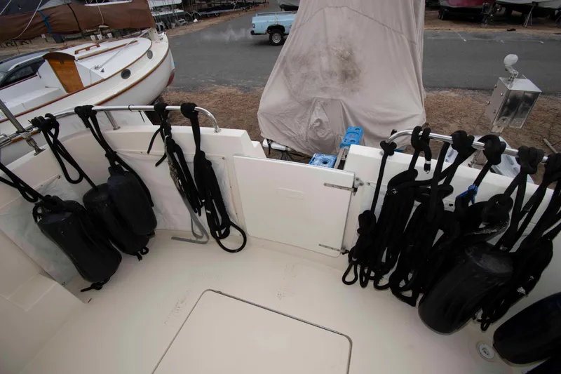 Slide: The Image of 1999 Camano 31 Troll boat deck with fenders and ropes, docked outdoors. - 3