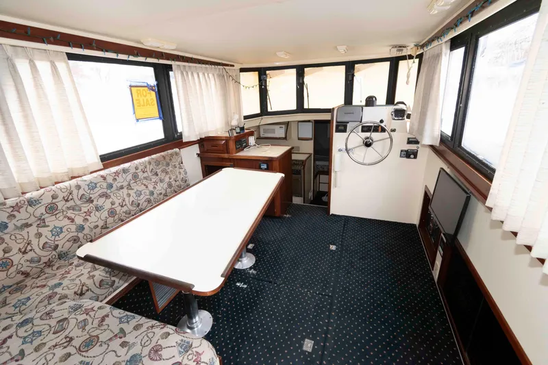 Slide: The Image of Interior of 1999 Camano 31 Troll boat with helm, table, and seating area. - 4