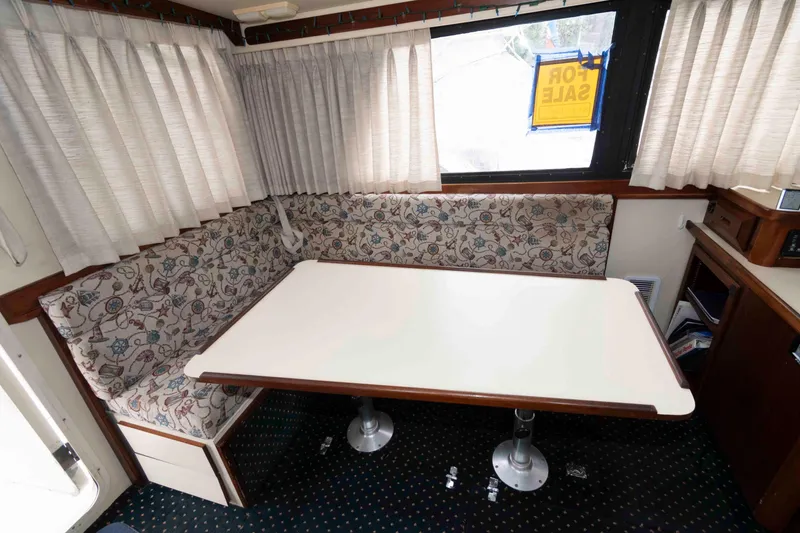 Slide: The Image of Interior of 1999 Camano 31 Troll boat with dining area and "For Sale" sign. - 5