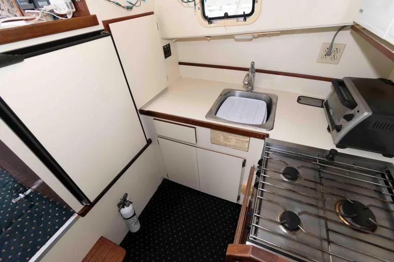 Slide: The Image of Compact kitchen in 1999 Camano 31 Troll boat with stove, sink, and refrigerator. - 8
