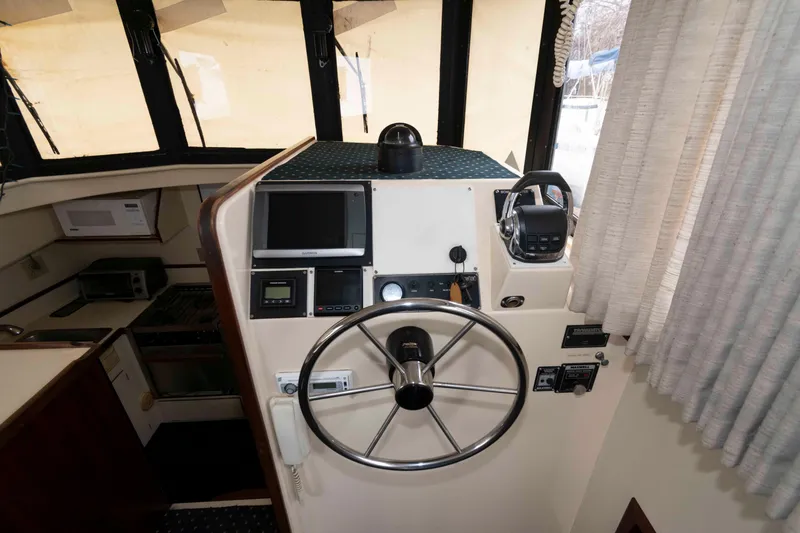 Slide: The Image of Interior helm of 1999 Camano 31 Troll boat with steering wheel and navigation equipment. - 9