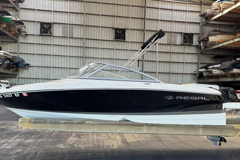 Slide: The Image of 2014 Regal 1900 ES Bowrider boat in storage, black and white exterior. - 2