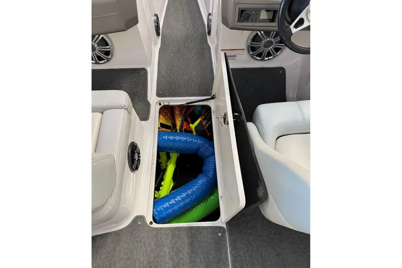 Slide: The Image of 2014 Regal 1900 ES Bowrider interior storage compartment with colorful equipment. - 24