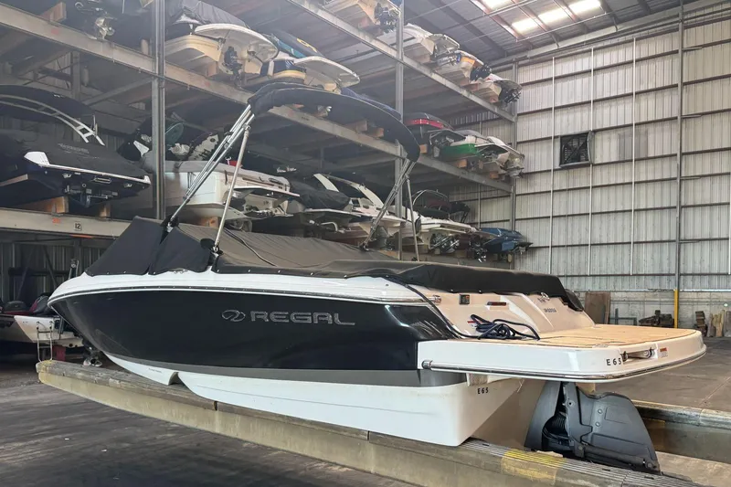 Slide: The Image of 2014 Regal 1900 ES Bowrider in storage, black and white exterior, covered, indoor facility. - 31