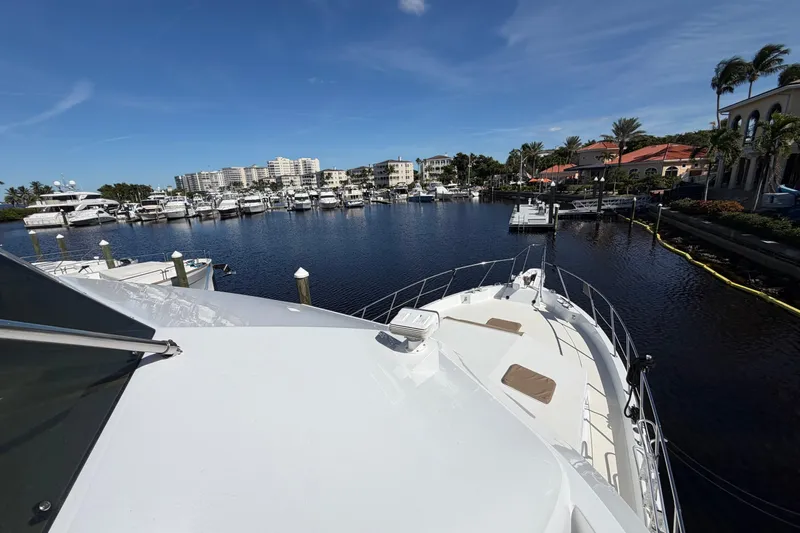 Slide: The Image of 1991 Hatteras 70 Motor Yacht docked in a scenic marina with clear skies. - 10