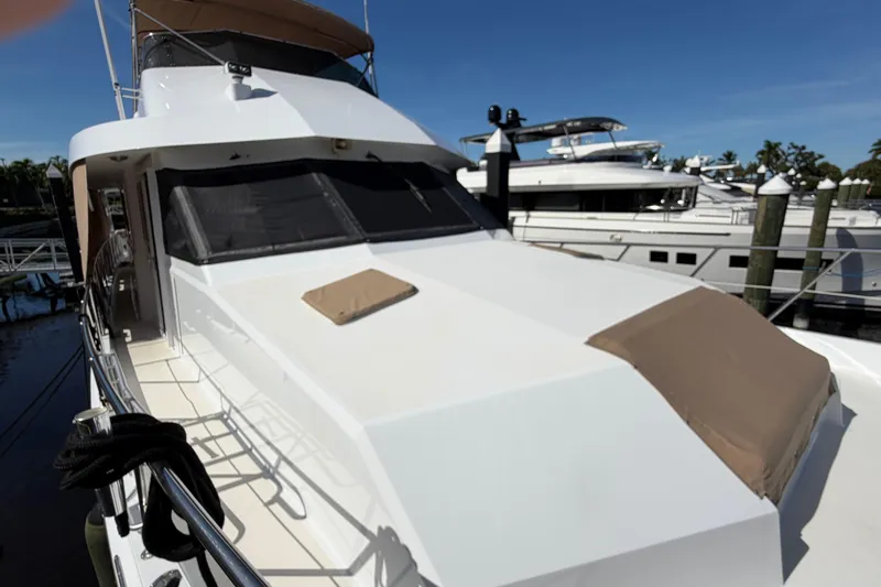 Slide: The Image of 1991 Hatteras 70 Motor Yacht docked, showcasing sleek design and spacious deck. - 19