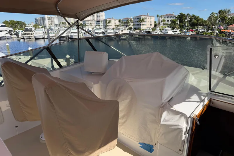 Slide: The Image of 1991 Hatteras 70 Motor Yacht deck with covered seating, docked at marina. - 39