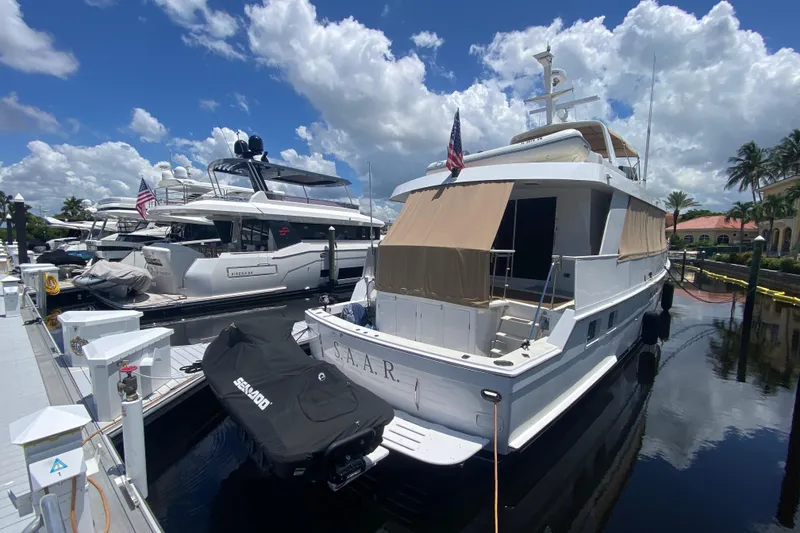 Slide: The Image of 1991 Hatteras 70 Motor Yacht docked under a bright blue sky. - 4