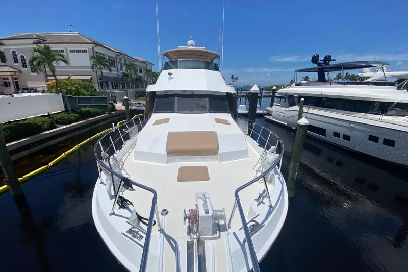 Slide: The Image of 1991 Hatteras 70 Motor Yacht docked at marina under clear blue sky. - 5