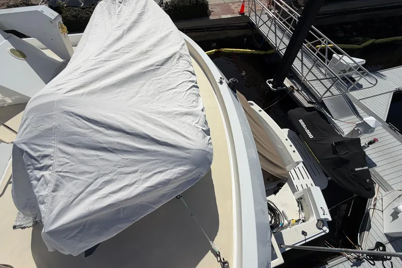 Slide: The Image of 1991 Hatteras 70 Motor Yacht deck with covered equipment and docked jet ski. - 52