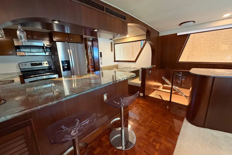 Slide: The Image of Luxurious interior of a 1991 Hatteras 70 Motor Yacht with modern kitchen and seating area. - 58