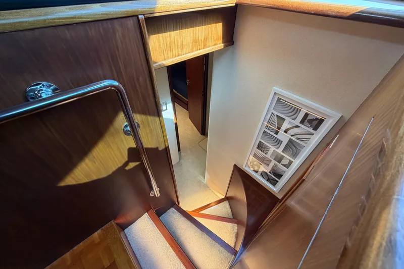Slide: The Image of Interior staircase of 1991 Hatteras 70 Motor Yacht with wooden finish and modern decor. - 74