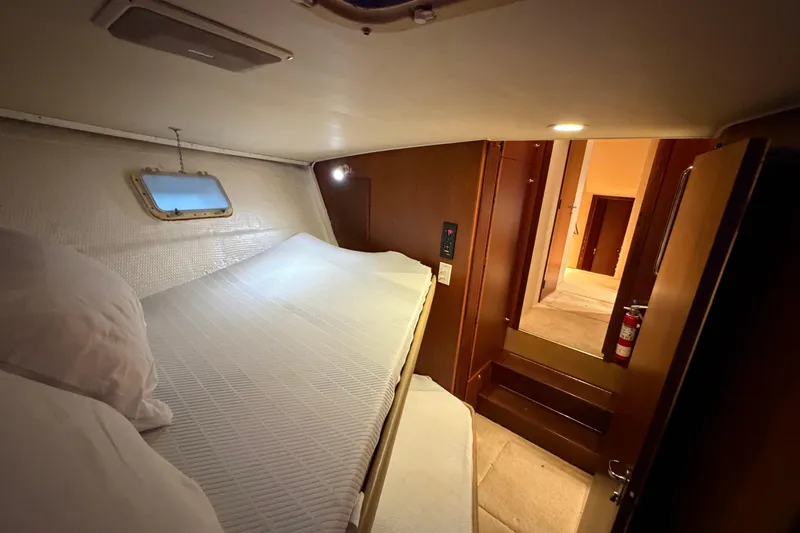 Slide: The Image of Cozy cabin interior of 1991 Hatteras 70 Motor Yacht with bed and porthole. - 91
