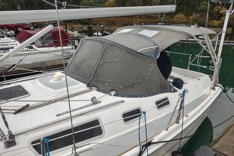 Slide: The Image of 2003 Hunter 356 sailboat docked, featuring a protective canopy and sleek design. - 13