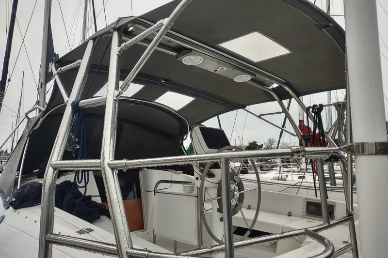 Slide: The Image of 2003 Hunter 356 sailboat cockpit with steering wheel and protective canopy. - 16