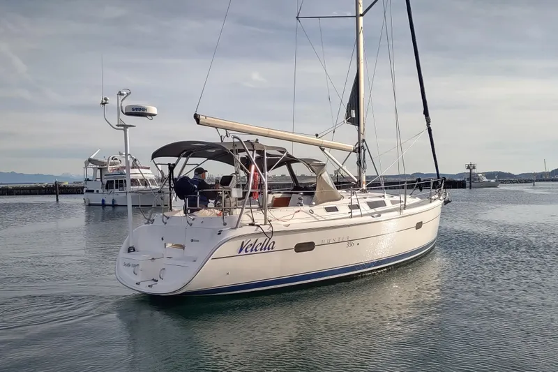 Slide: The Image of Sailboat "Velella," Hunter 356, 2003 model, cruising in calm waters near a marina. - 2
